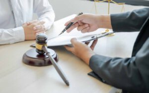 Anwalt Hand hält Stift und bietet rechtliche Beratung Geschäftsstreitigkeiten Service im Büro mit Gerechtigkeit Skala und Hammer